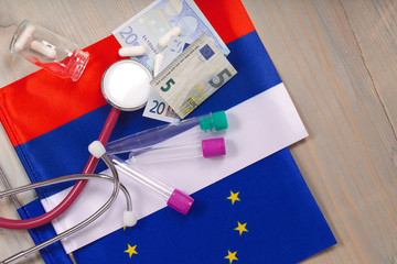 Fototapeta premium Medication,test tubes,money and stethoscope on European and Russian flags