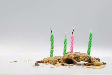 four birthday candle on mix nut and raisin cookies white background.