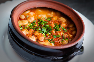 Baked beans casserole with parsley and paprika in ceramic pot