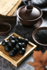 Chinese black sesame ball on bamboo plate with tea