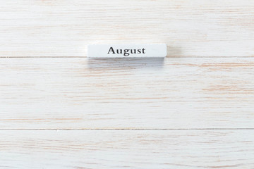 Wooden block of calendar with month August on wood background