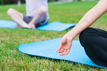 Yoga concept. woman relaxing while meditating on a carpet outdoors on a ground. Med behind