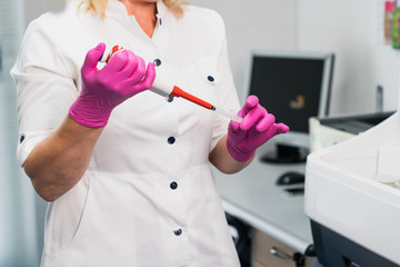 The doctor holding a vaccine to prevent the Covid-19 virus and test tube with blood sample for COVID-19 test, novel coronavirus 2019.