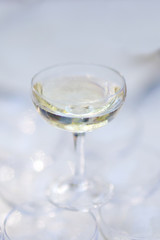 White transparent glass with champagne. On a Sunny festive summer day, the glass shimmers and sparkles in the sun.