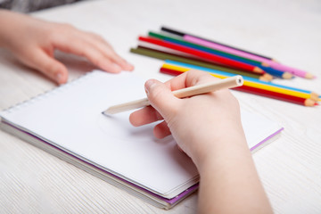 Fototapeta na wymiar Children's hands draw with crayons