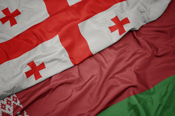 Fototapeta premium waving colorful flag of belarus and national flag of georgia.