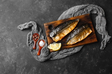 Delicious baked mackerel fillet with paprika, garlic and lemon, on a dark wooden Board with spices...