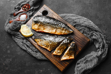 Delicious baked mackerel fillet with paprika, garlic and lemon, on a dark wooden Board with spices...