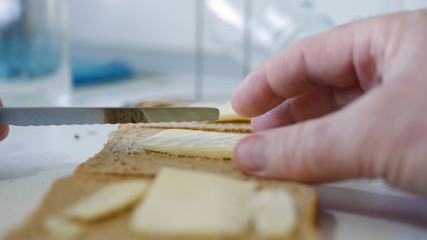 Morning Breakfast with Butter on the Toast, Spreading Margarine on a Fresh Slice of Bread in the Kitchen