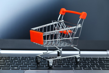 empty metal shopping cart on laptop keyboard in front of screen
