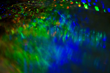 Dark abstract background with overflow, multicolored, rainbow bokeh and highlights.