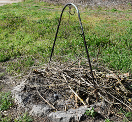 Metal stand for a cauldron to cook outdoors with firewood. A place for barbecue.