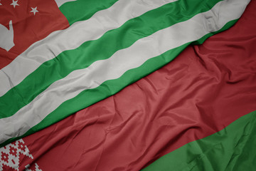 waving colorful flag of belarus and national flag of abkhazia.
