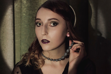 Portrait of a young woman in the style of the 20s. Vintage makeup and hairstyle.