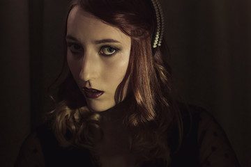 Portrait of a young woman in the style of the 20s. Vintage makeup and hairstyle.