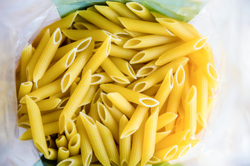 raw italian penne rigate macaroni pasta inside clear packaging