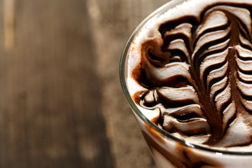 Cappuccino decorato con cacao su sfondo tavole di legno