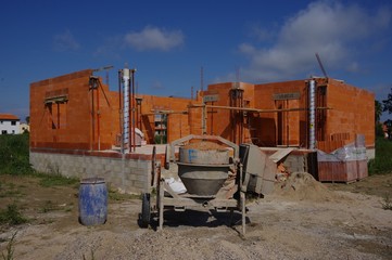 chantier de maison en construction et bétonnière à l'arrêt