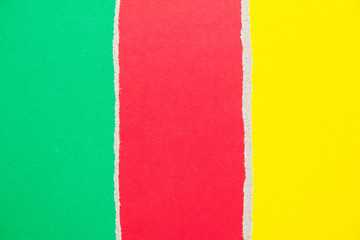 Red, green and yellow ripped pieces of cardboard paper texture background. Copy space for text...