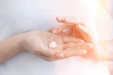 Close-up of a drop of cream on female hands. Moisturizing hands. Skin care.