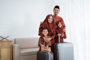 Asian Muslim family after packing clothes with suitcases to carrying mudik to their hometown