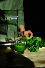 Man pouring in glass healthy detox smoothie, cooking with blender