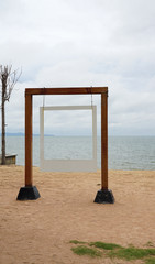 White picture frame hanging on the timber pole with sea background