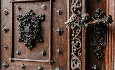 Rare beautiful wood door with handmade door handle. Bronze art and vintage keyholeof enter in castle. Woodwork craftsmanship.