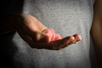 Female holding pink condom in hand.