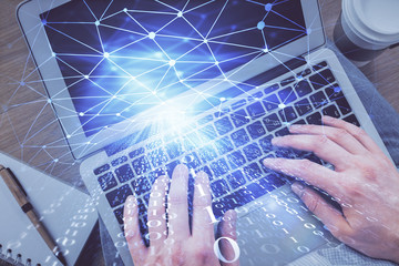 Multi exposure of man's hands typing over computer keyboard and data theme hologram drawing. Top view. Technology concept.