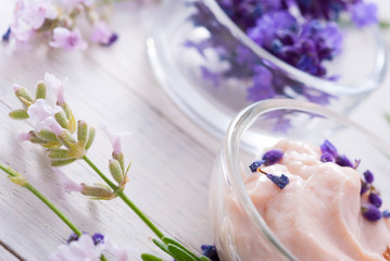 cosmetic cream and lavender flowers on white wood table background