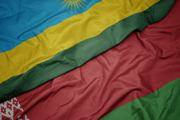 waving colorful flag of belarus and national flag of rwanda.