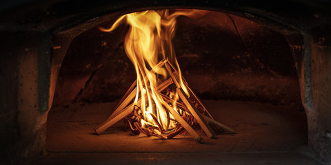 lighting the fire inside a traditional wood-burning oven