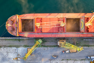Top view from drone of a large ship loading grain for export. Water transport