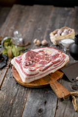 Salted brisket with spices on wooden board with garlic pepper jar wooden