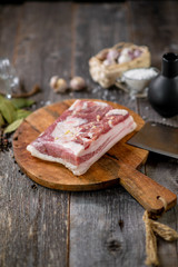 Salted brisket with spices on wooden board with garlic pepper jar wooden