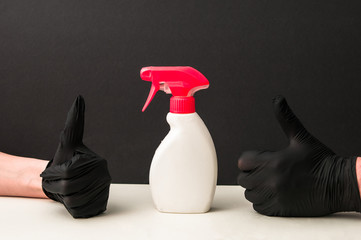 a doctor in a blue medical gown and gloves treats his hands with antiseptic, black background and space for text