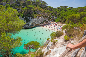 Bathers refresh themselves in the fresh and transparent waters of a bay on the island of Menorca in Spain. - obrazy, fototapety, plakaty