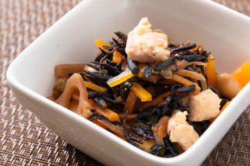 こげ茶のランチョンマットに乗るひじきの煮物