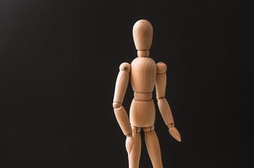wooden mannequin on a black background, Wooden mannequin on black table and blue background. trun...