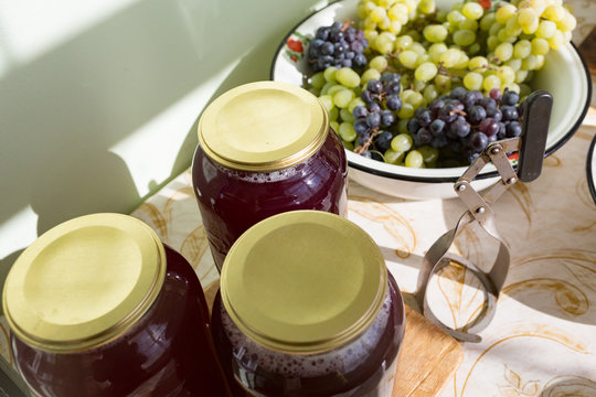 Grape juice in cans, cooked in a juicer, harvesting juice from a grape harvest