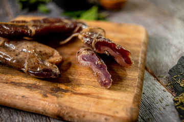 Beef jerky on wooden board with zest lemon spices salt