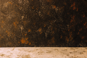 Old black color painted concrete with a black scuffed rustic background and rust and a desk with gray concrete, horizontal orientation. Copy space