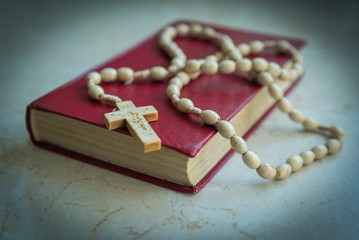 
rosary and holy bible on the table