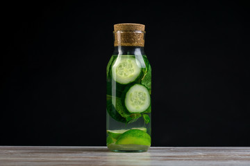 Detox water with cucumber, lime and mint in bottles