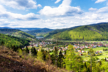 Aerial view of Miedzybrodzie town in Beskid Maly mountain range. Lake and dam in the background. Beautiful spring panorama.