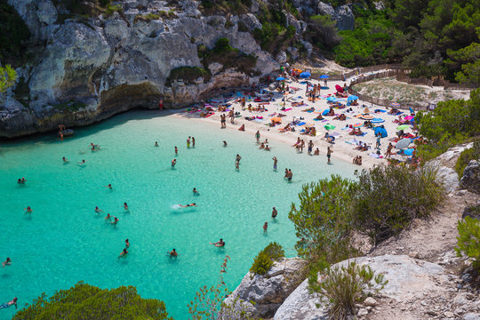 Bathers refresh themselves in the fresh and transparent waters of a bay on the island of Menorca in Spain.
