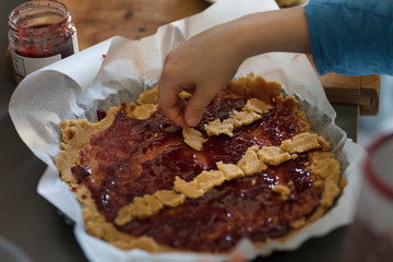 child preparing a very goog jam tart
