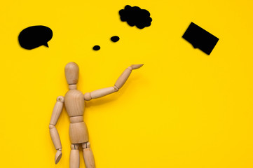 Wooden figurine holding blank placard against color background