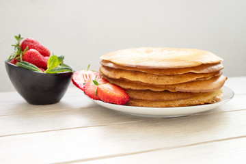 Homemade fresh pancakes with strawberries. Place for text. Side view.